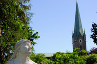 The head of a statue of a woman, apparently looking up towards the cathedral's tower (seen in the background).